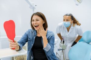 A satisfied patient is thrilled after asking questions to ask your dentist.