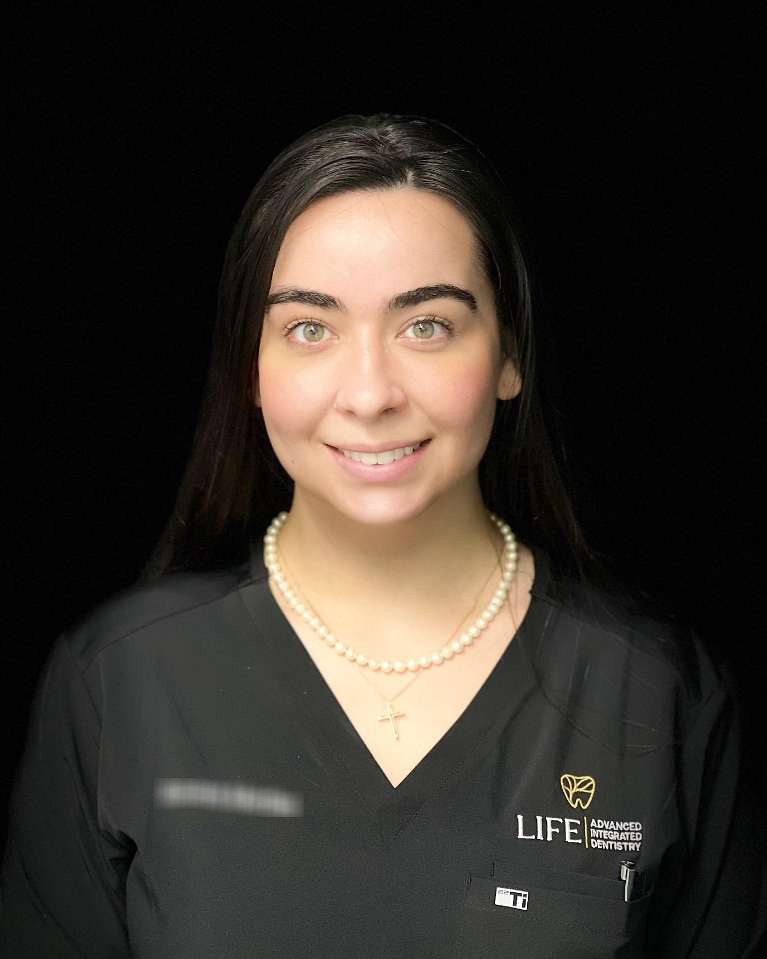 Smiling dental professional in black uniform.